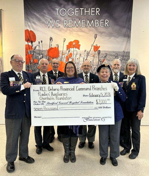 Members of Branch 8 of The Royal Canadian Legion stand with hospital representatives in front of a “Together We Remember” poppy backdrop, holding a ceremonial cheque for $7,000 from The Royal Canadian Legion Ontario Provincial Command Branches and Ladies’ Auxiliary Charitable Foundation in support of a bed for the Cancer & Medical Care Clinic at Stratford General Hospital.